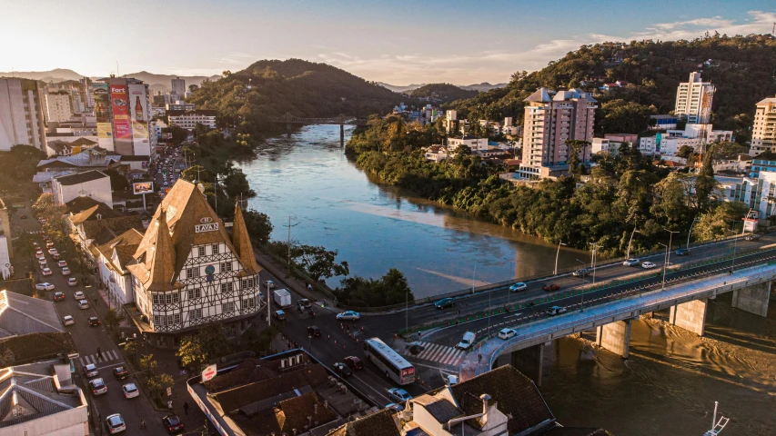 an aerial view of a river flowing next to a bridge