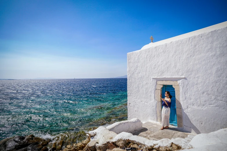 the woman in the white dress is standing outside a window