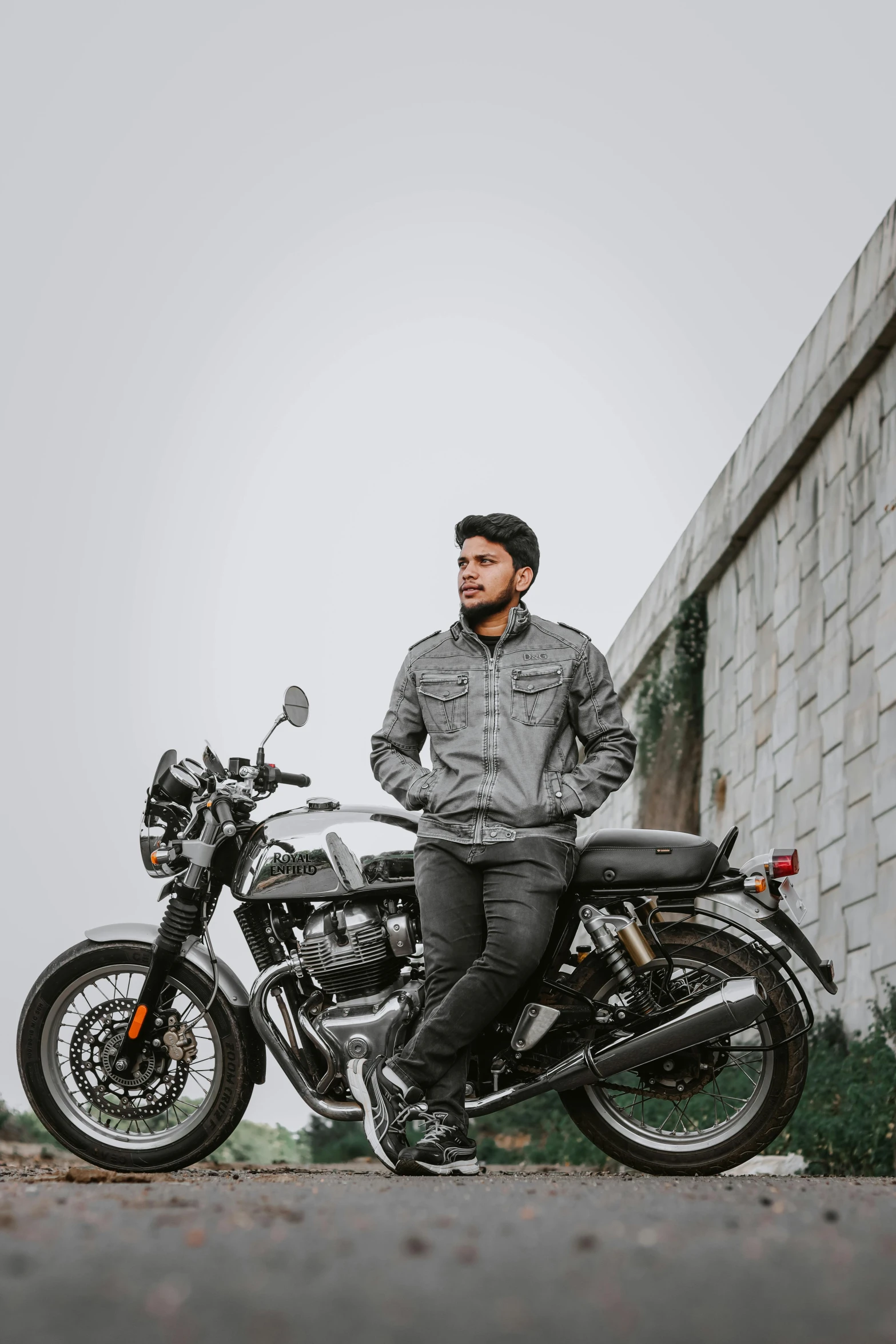 a man sitting on a motorcycle next to brick building