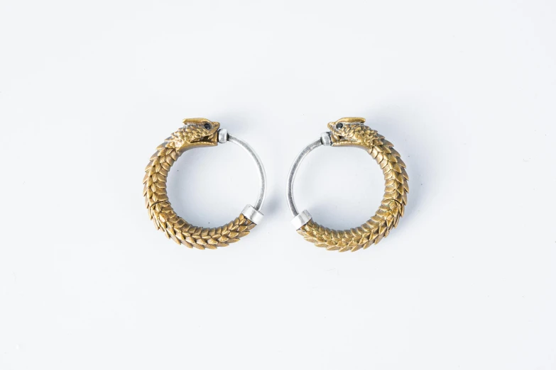 two pieces of silver and gold metal ear rings