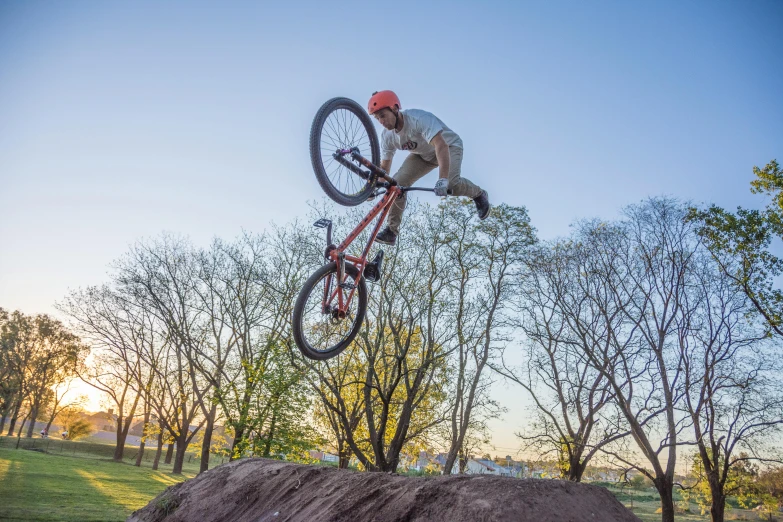 a person jumping over a large hill with a bicycle