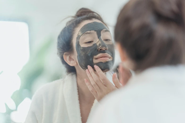 a woman with a mask on looks into a mirror