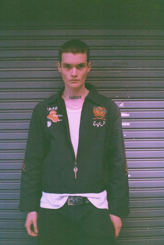 a young man stands in front of a garage door