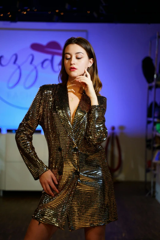 a woman is posing wearing a sparky metallic suit