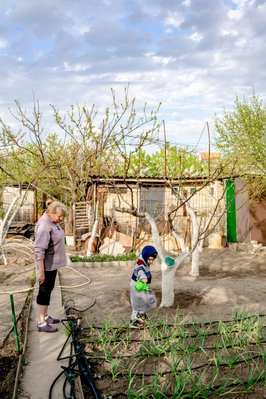 a woman and child standing near trees that have been growing