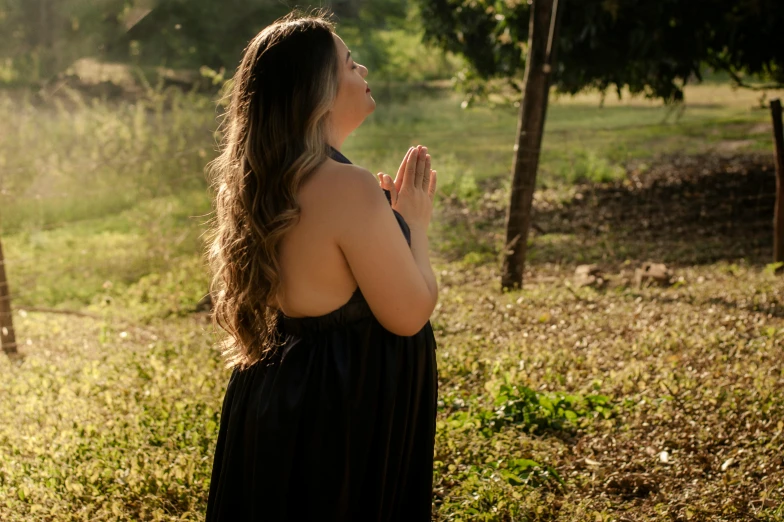 a woman standing in a field looking up at the sky