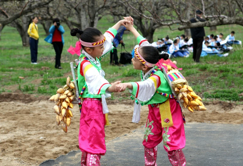 two girls are dancing together on the side of the road