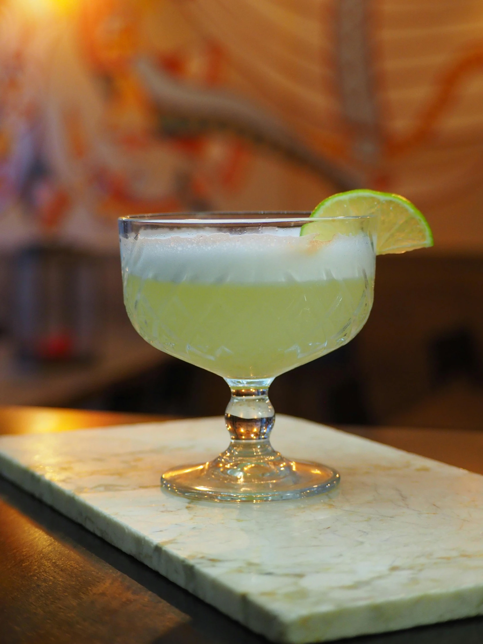 a green and yellow beverage on top of a marble table