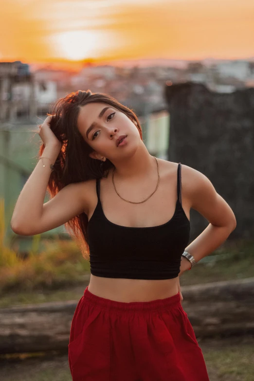 a woman poses for the camera wearing red pants