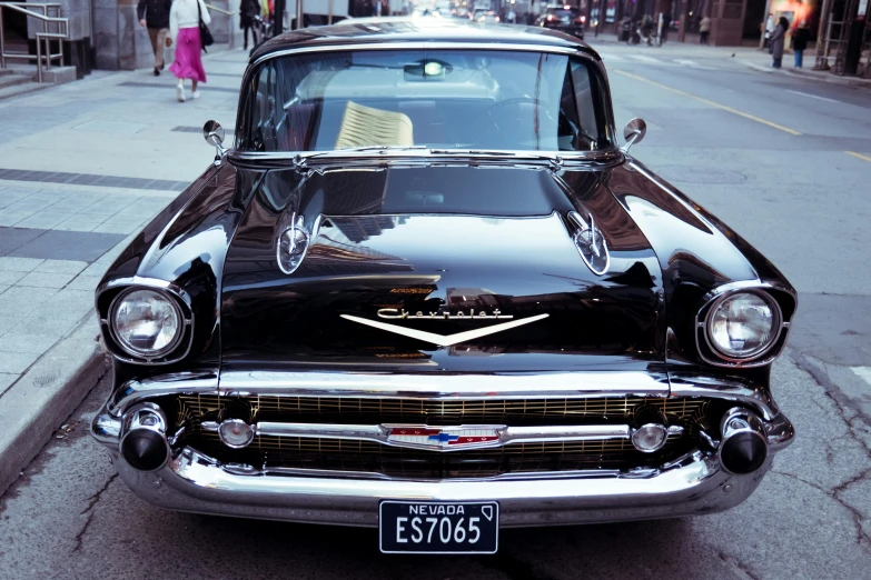 a classic chevrolet sits parked next to an empty city street