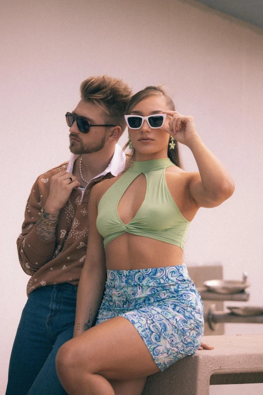 a man and woman wearing matching outfits posing in front of a camera