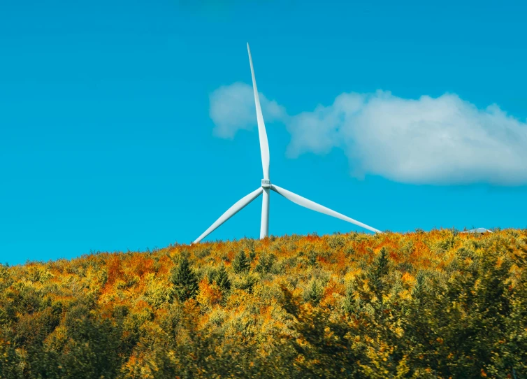 a windmill is pictured sitting high on a hill