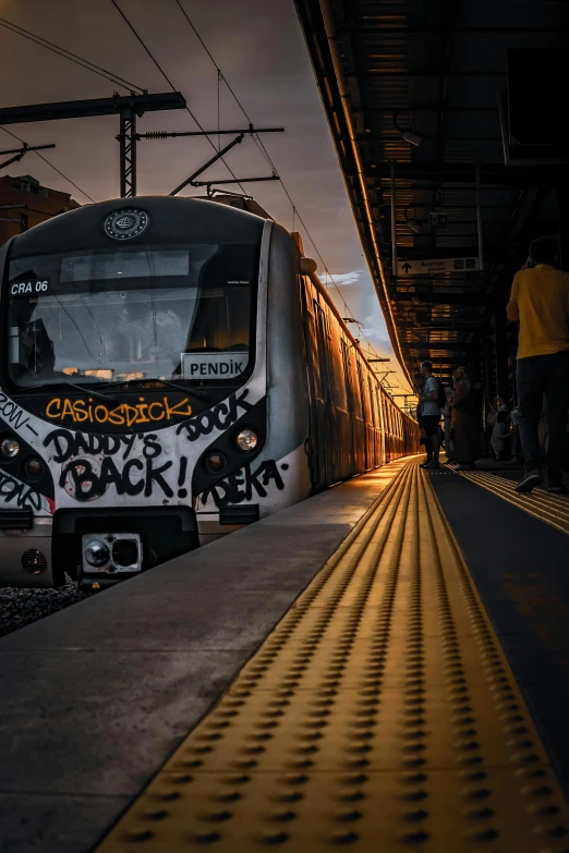 the train is going down the tracks and has spray paint on it