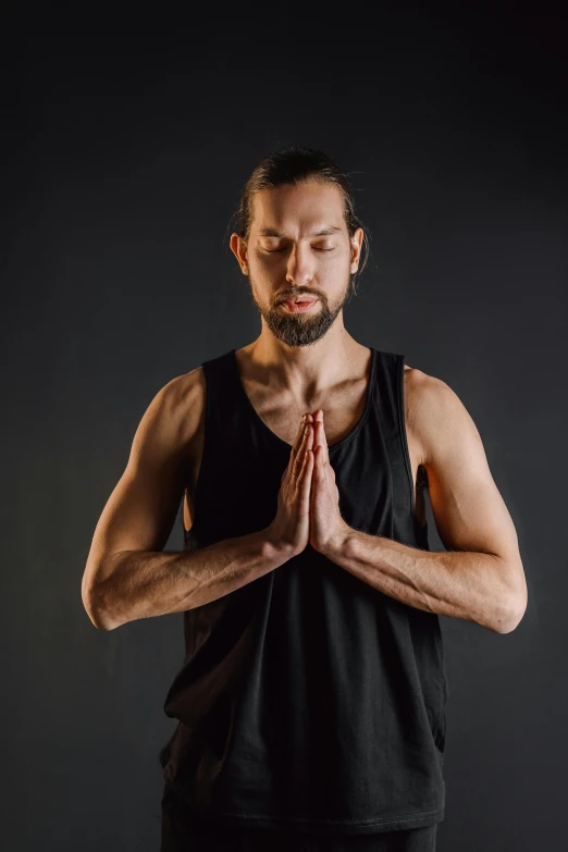 a man that has his hands folded up in yoga pose