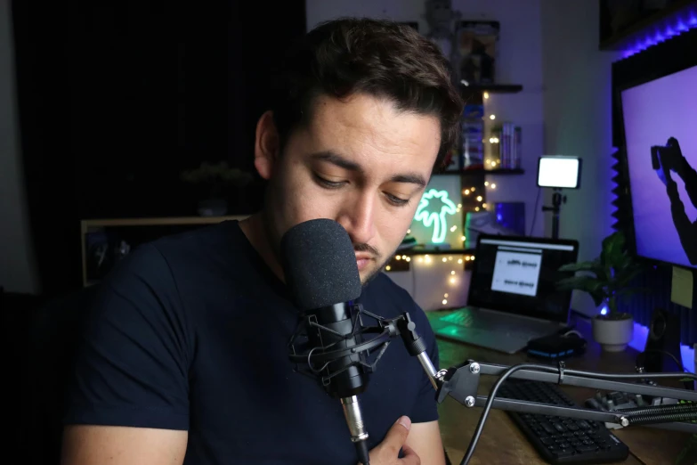 a man in a black shirt using a microphone