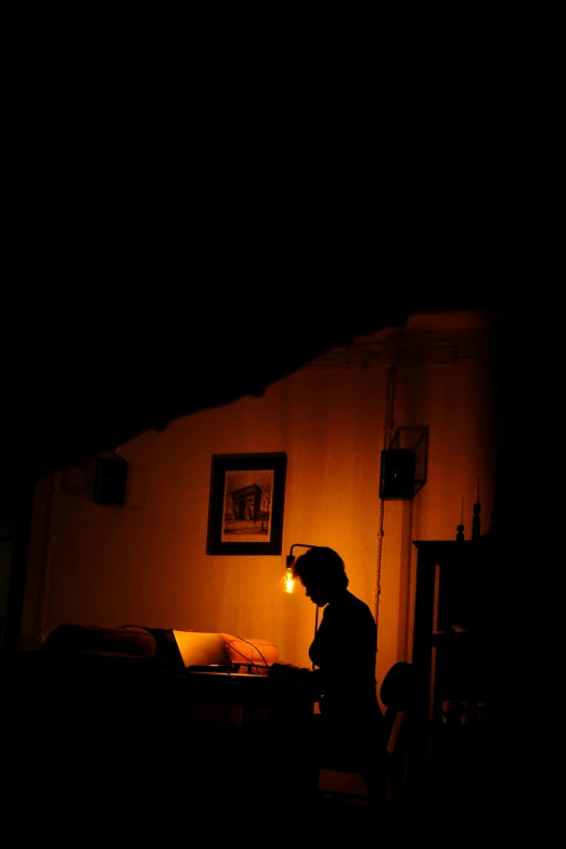 a person sitting in a room with a small light on