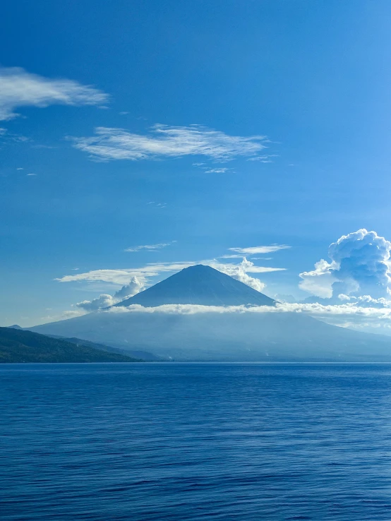 a large body of water sitting below a tall mountain