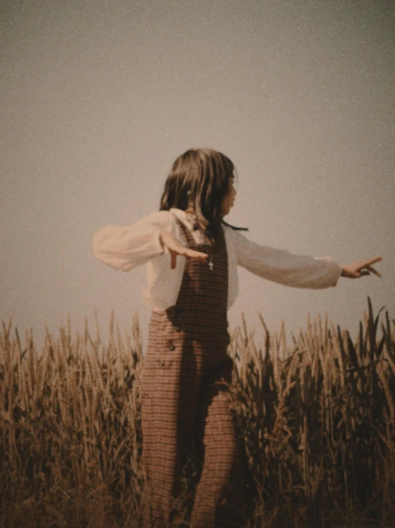 a person in a field with their arms out