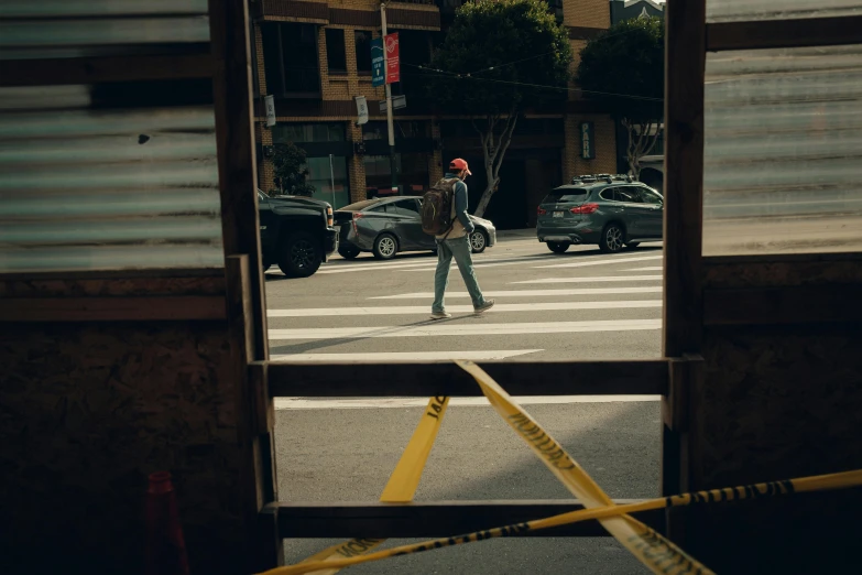 a man crosses the street as cars go by