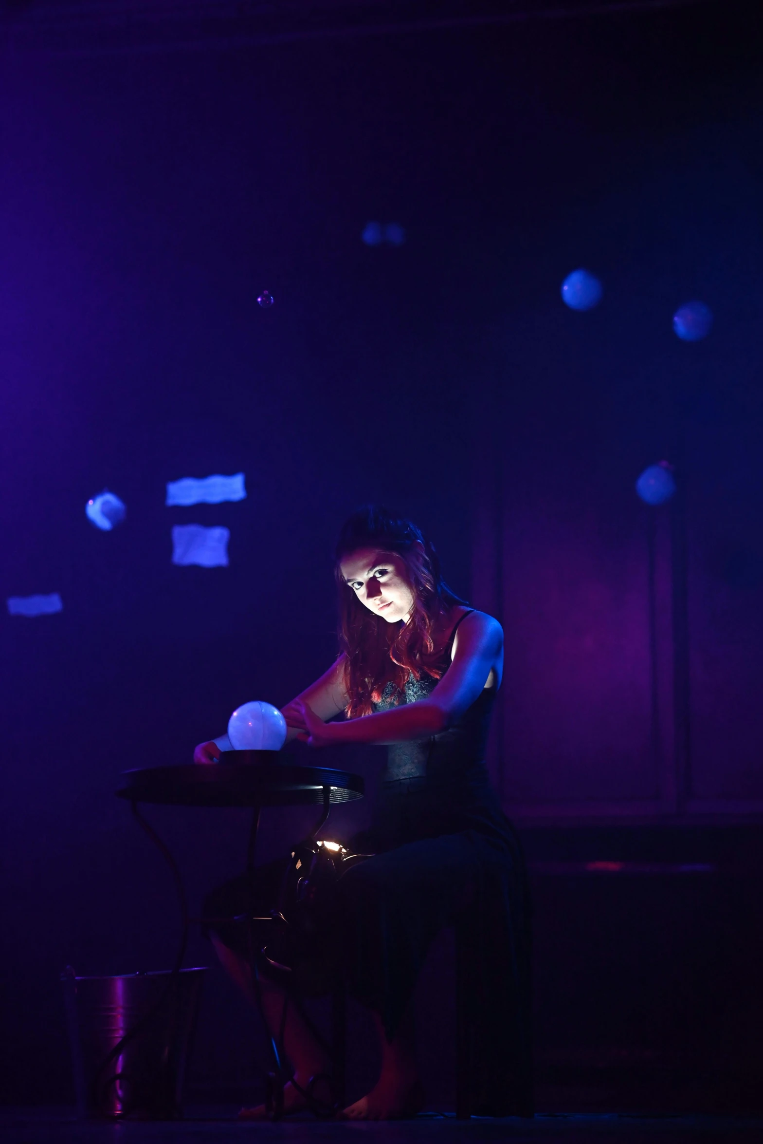 a woman sits in the middle of a stage