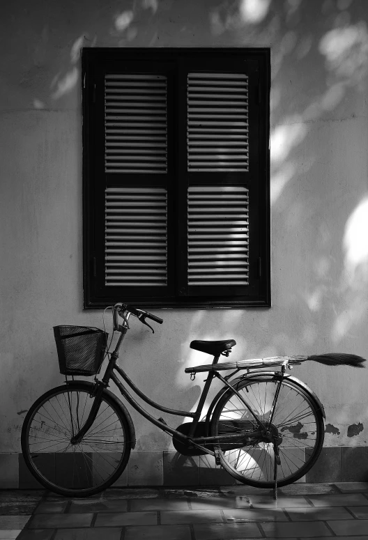 a bike sits in front of a window on a wall