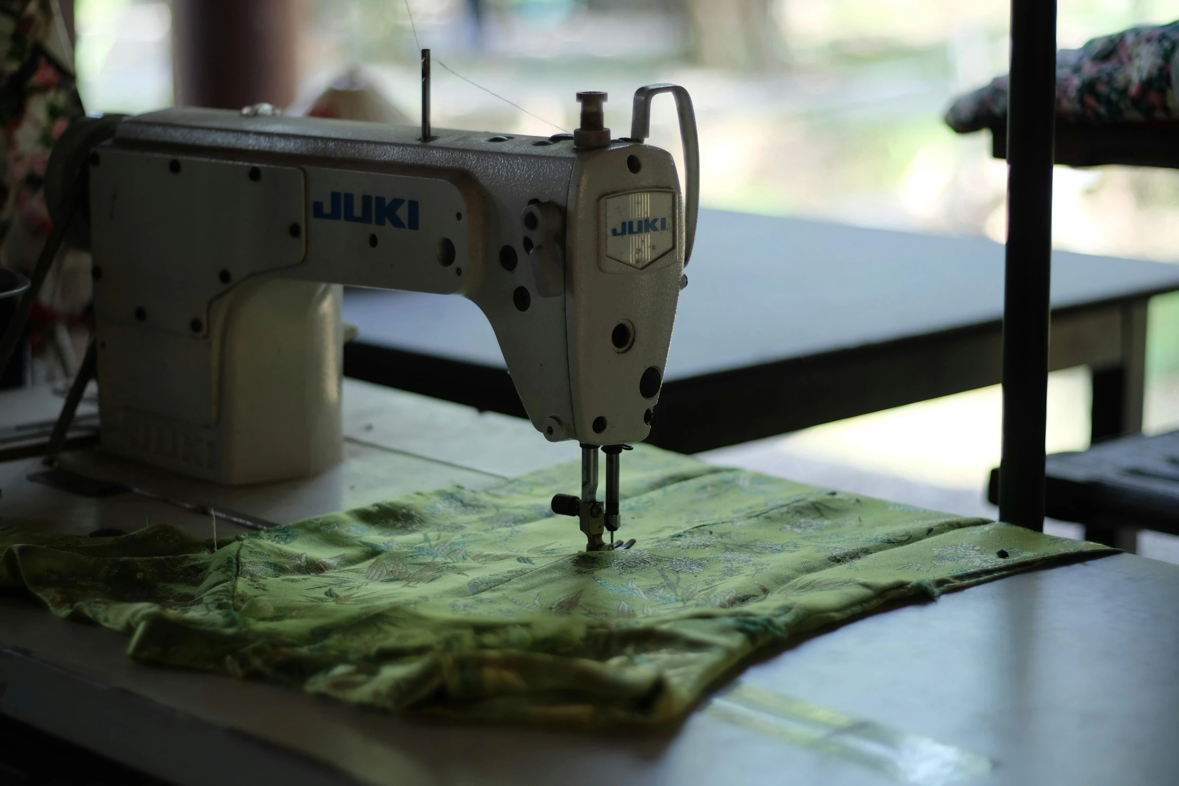 a sewing machine on top of a table next to some green material