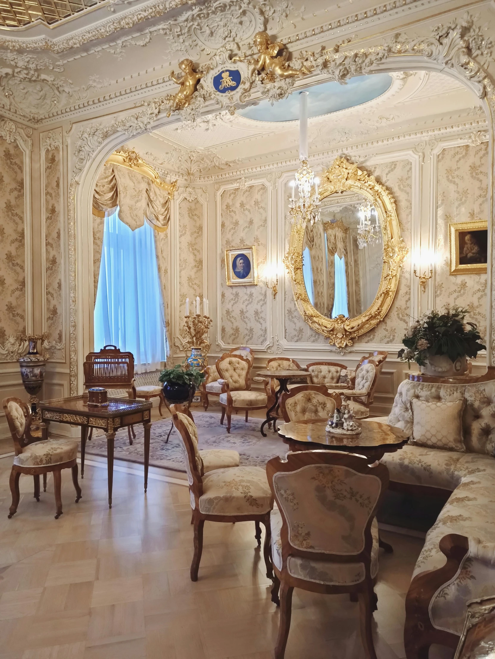 an ornate sitting room has chairs and tables in it