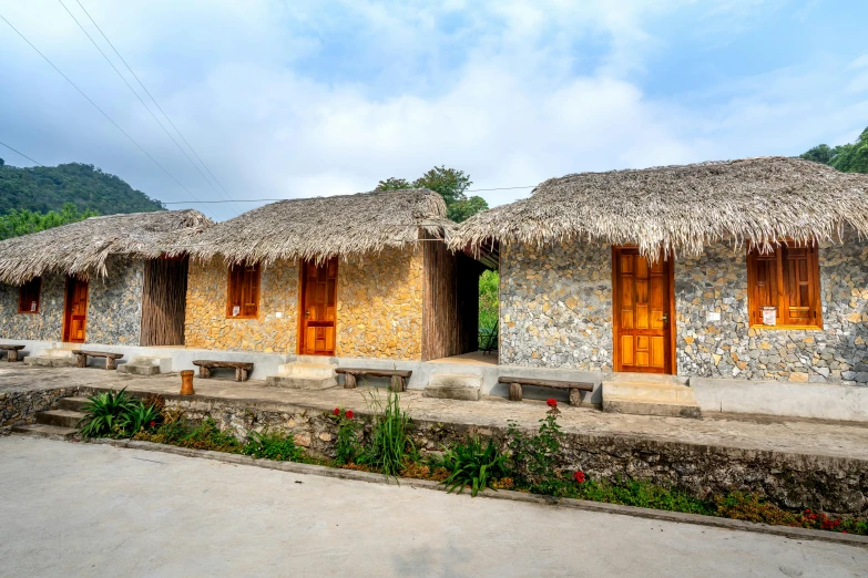 a stone building with several small windows and a thatched roof