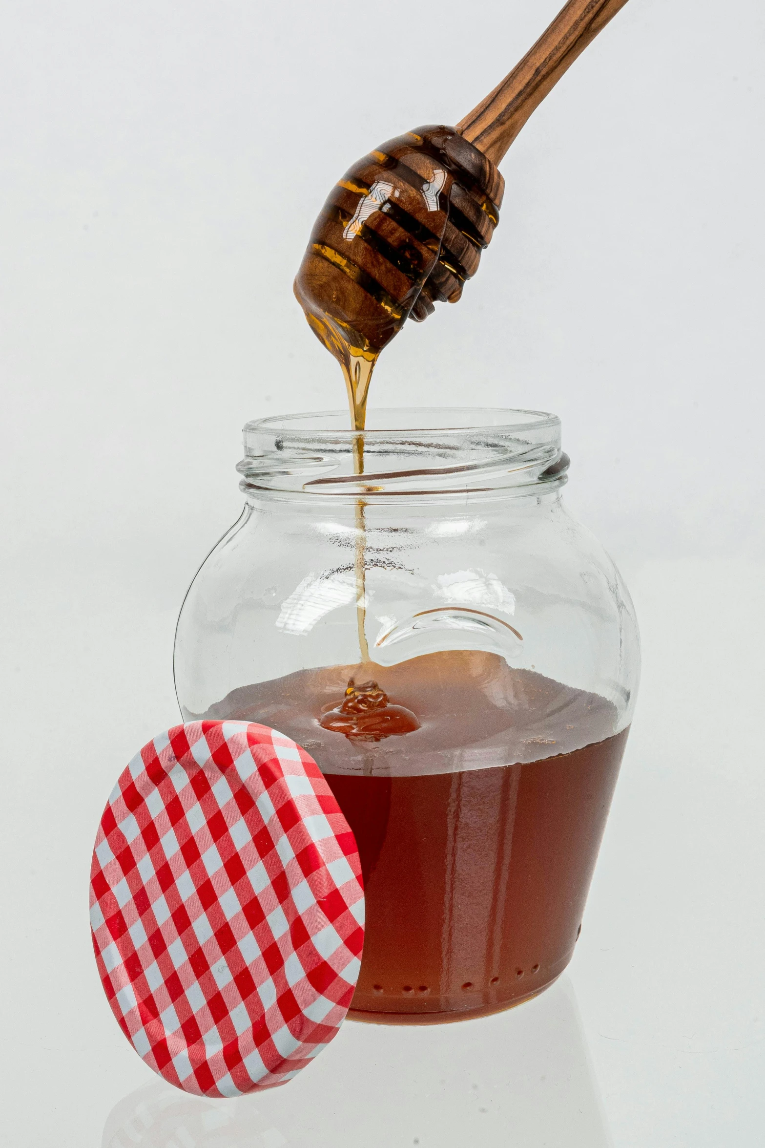 a honey in a jar being poured into the syrup