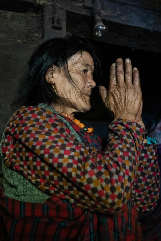 a woman standing with her hands together and looking through the glass