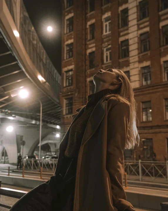 a woman stands outside an open train station at night