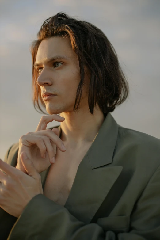 a woman in green is posing with a white cigarette