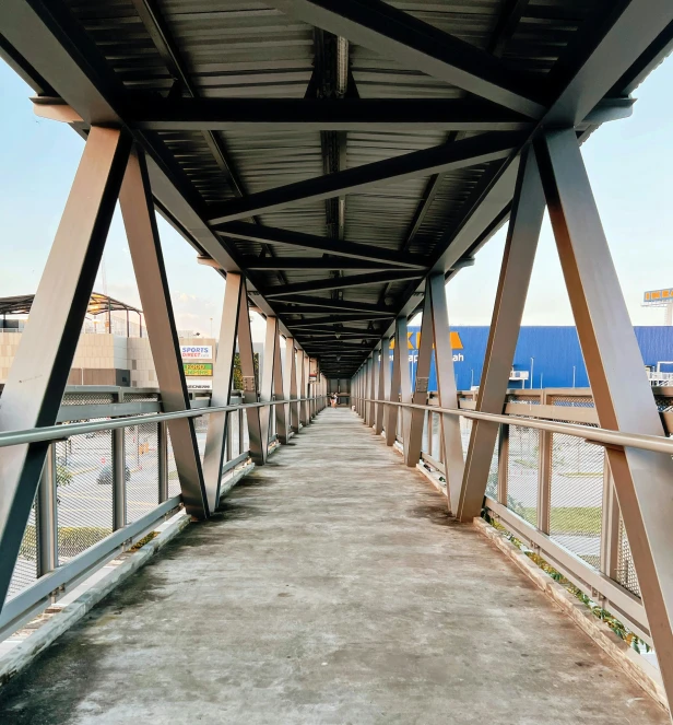 a walkway with some light colored steel structures on it