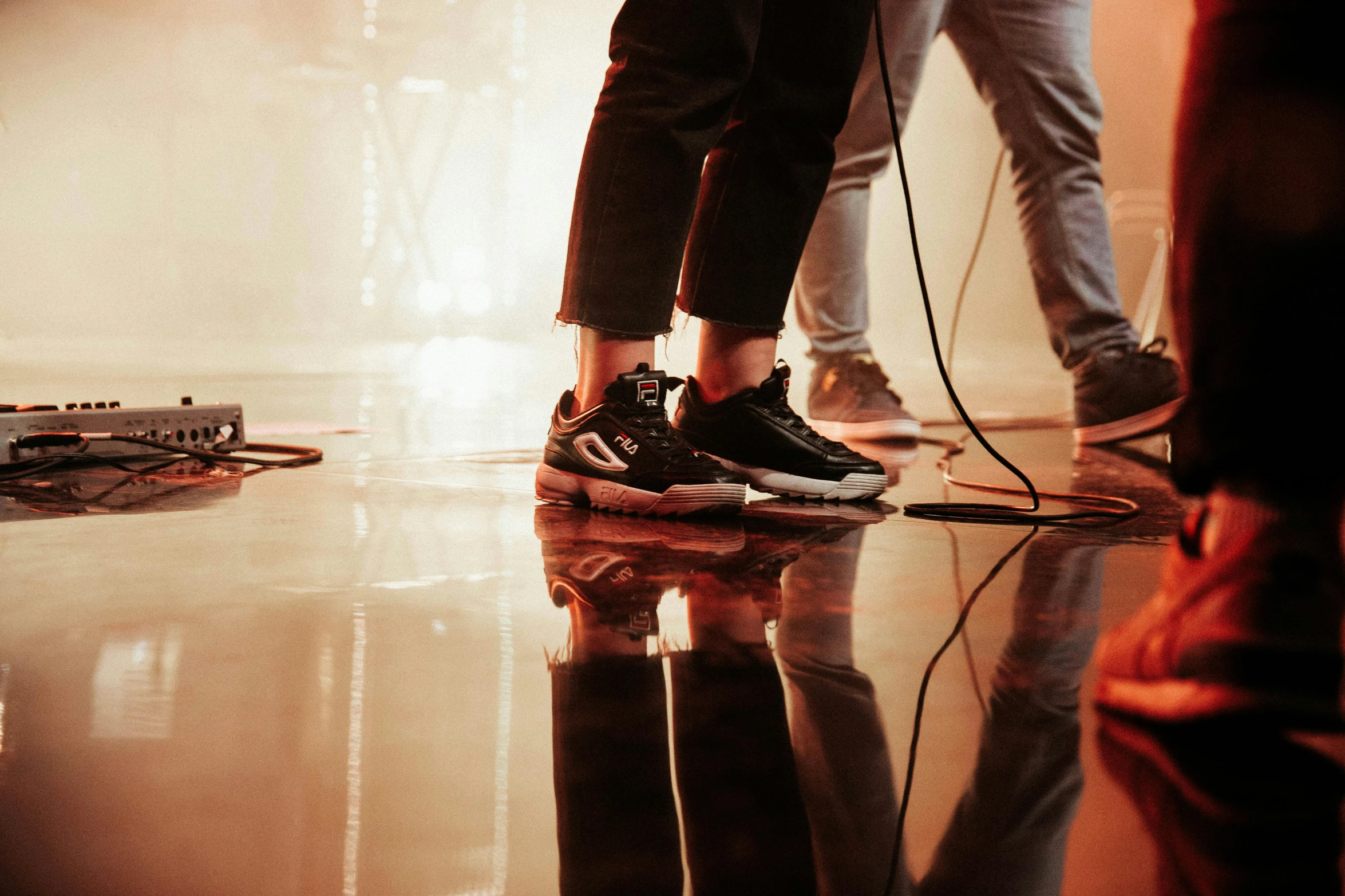 two people are walking on the ground with guitars and music equipment