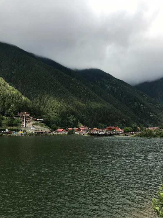 mountains and small houses sit over the water