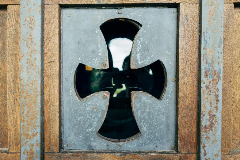 a glass window with the shape of a cross in it