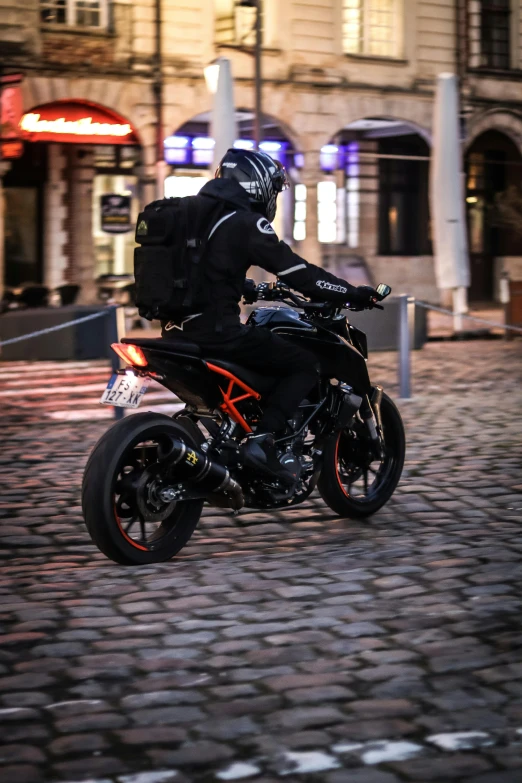 man riding on motorcycle with black seat in urban setting