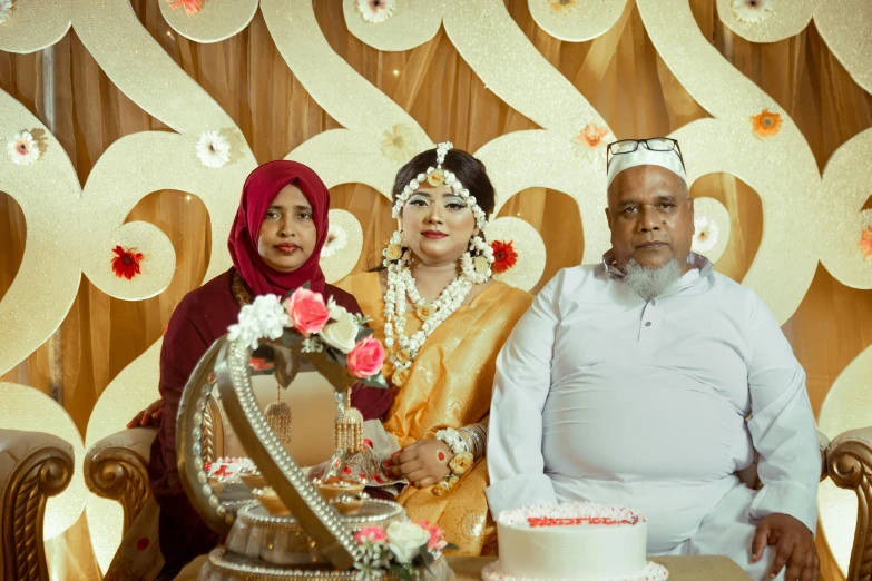 three people dressed in indian garb pose for a po