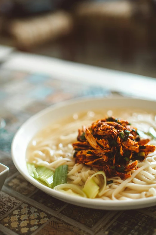 the bowl of ramen has a garnished chicken broth