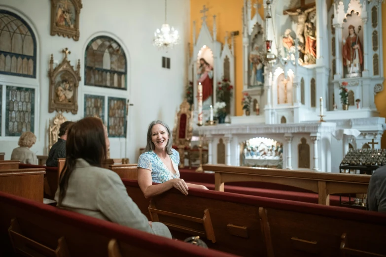 a woman sitting on pews at a church