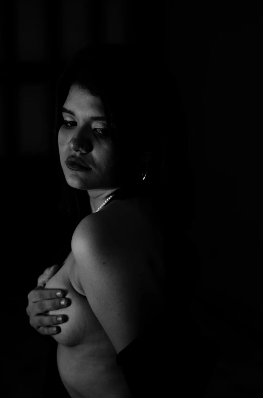 a woman in black is posing in the dark