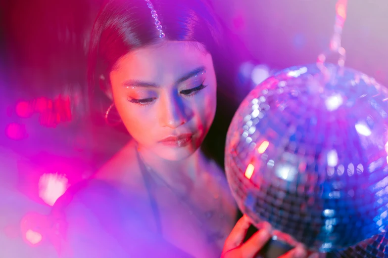 an image of a woman holding a disco ball