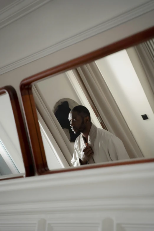 two people stand behind a mirror in a house