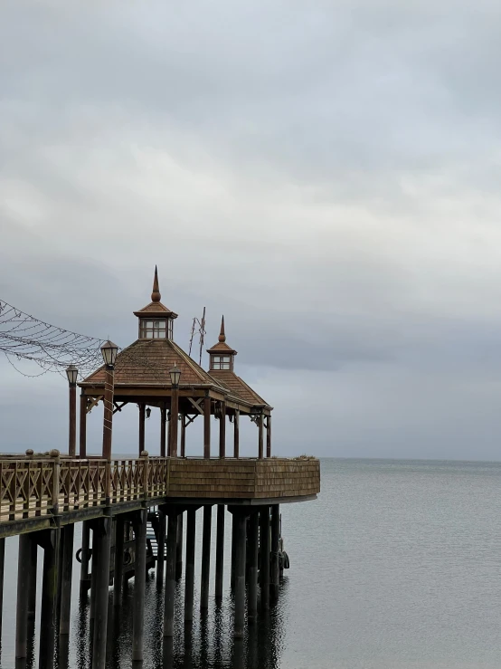 a large wooden gazebo sitting on the side of a pier