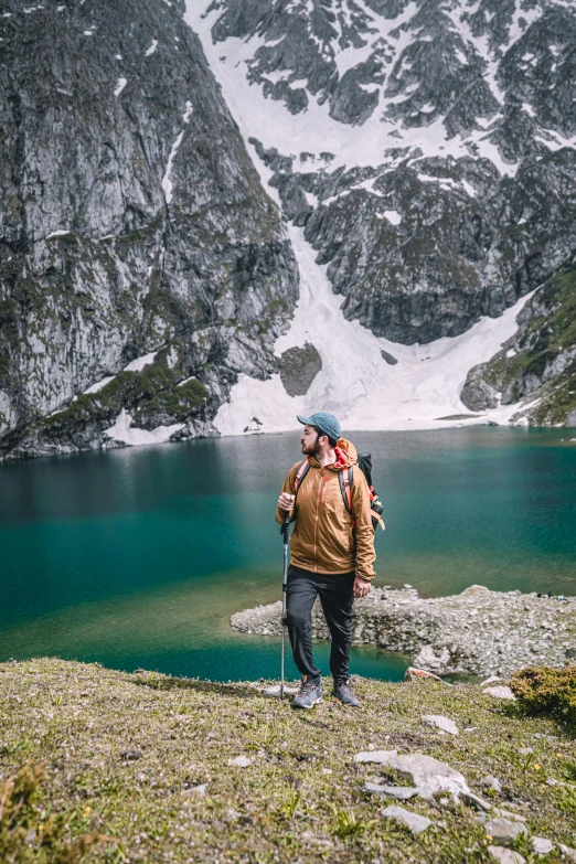 the backpacker is hiking near a lake in the mountains