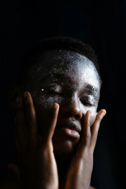 a man is looking directly at the camera while wearing silver glitter