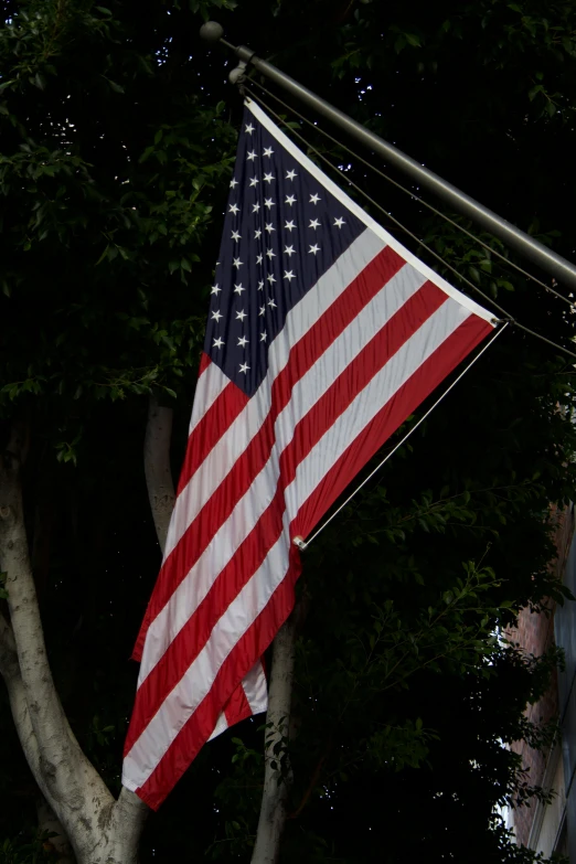 a large american flag hanging from the side of a building