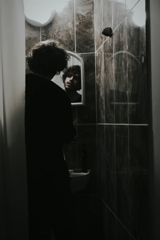 a person looking into the mirror in a bathroom