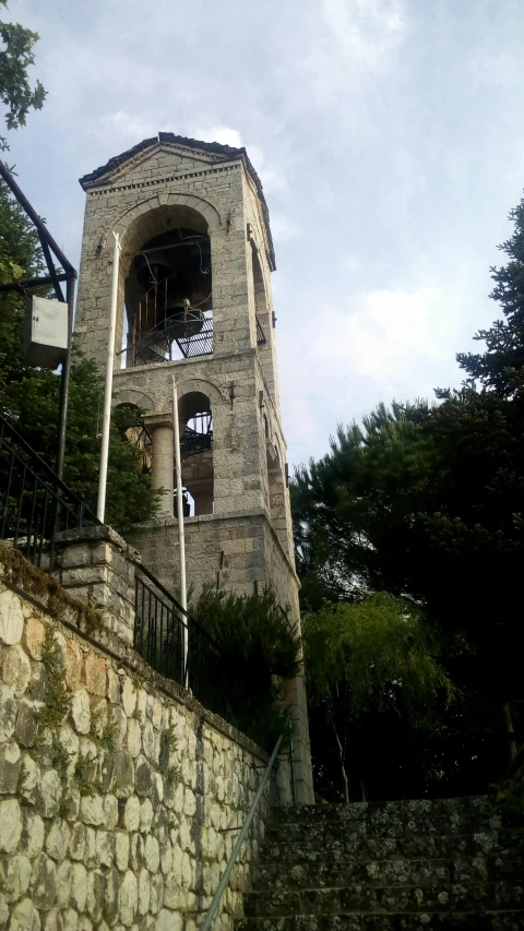 a tall tower with clocks next to some stone walls