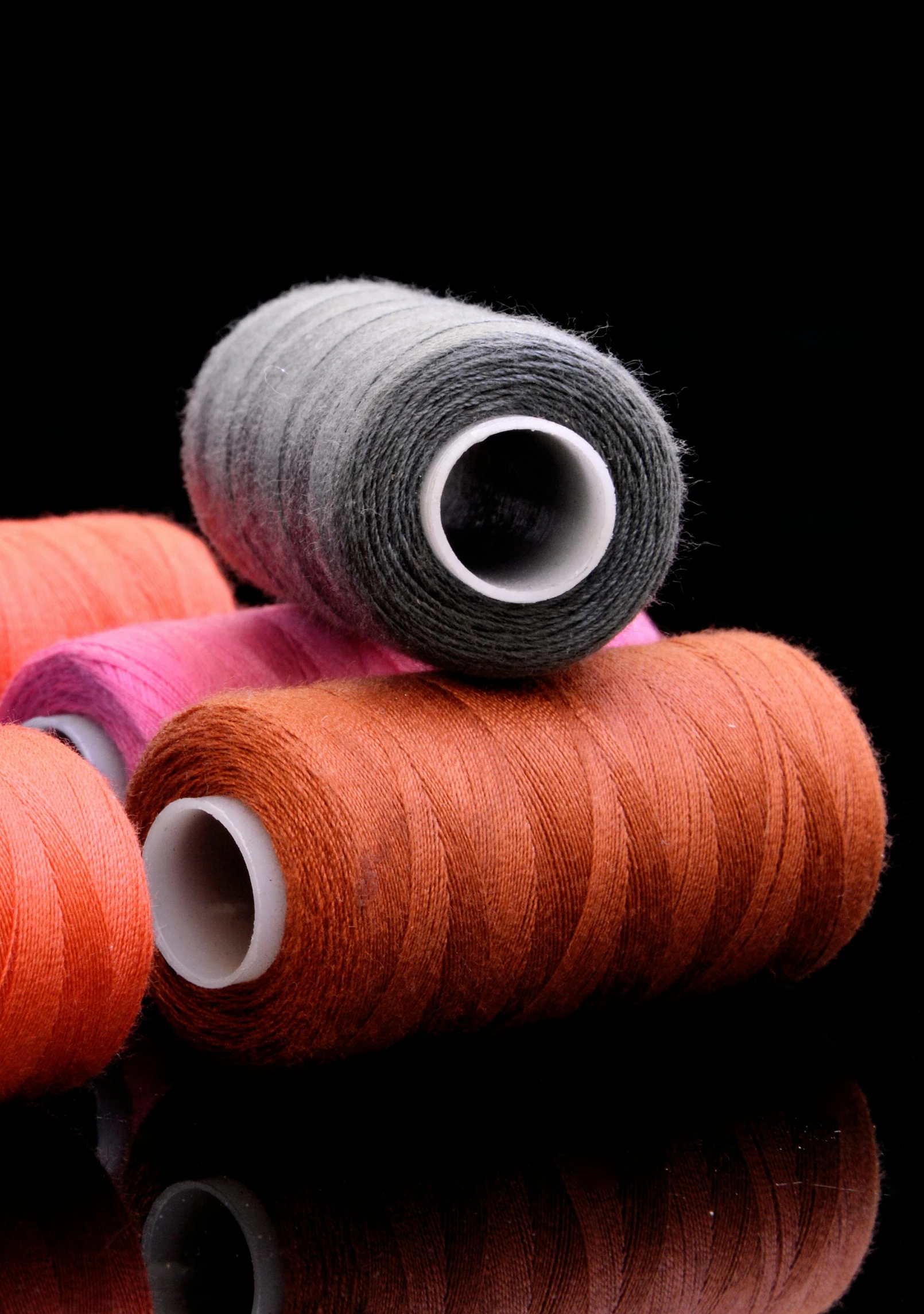 several skeins of thread and yarn on black background
